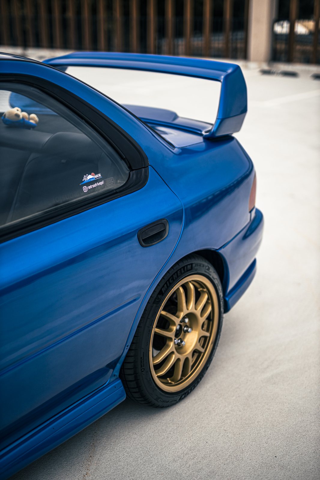 Spoiler STI i złota Speedline na tylnym błotniku niebieskiej Imprezy GC8. Fot. Wowson